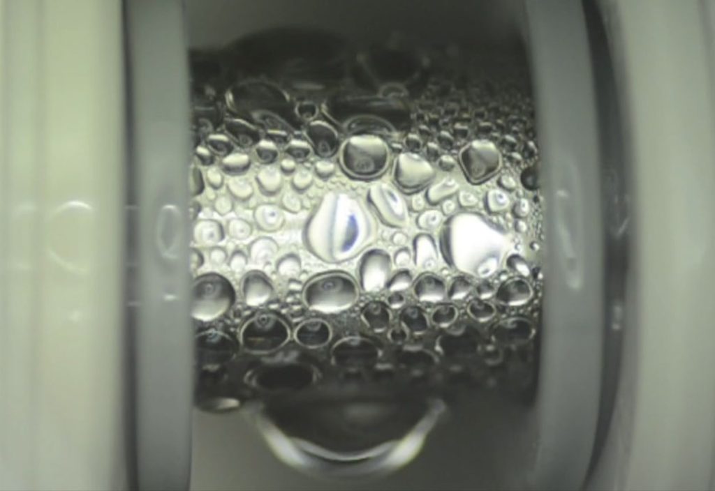 Specialised thin coatings developed by the MIT team cause even low-surface-tension fluids to readily form droplets on the surface of a pipe, as seen here, which improves the efficiency of heat transfer. Image courtesy of the researchers