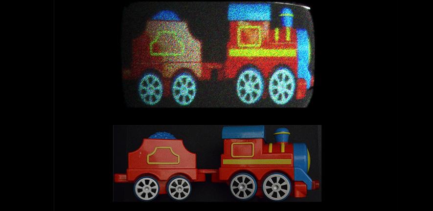 An image of a toy train captured with a camera (bottom) is reproduced with holobricks in 3D form (top). Image: CAPE