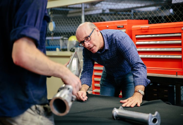 Professor Michael Smart examines a scramjet engine at the UQ Centre of Hypersonics ground-testing facility