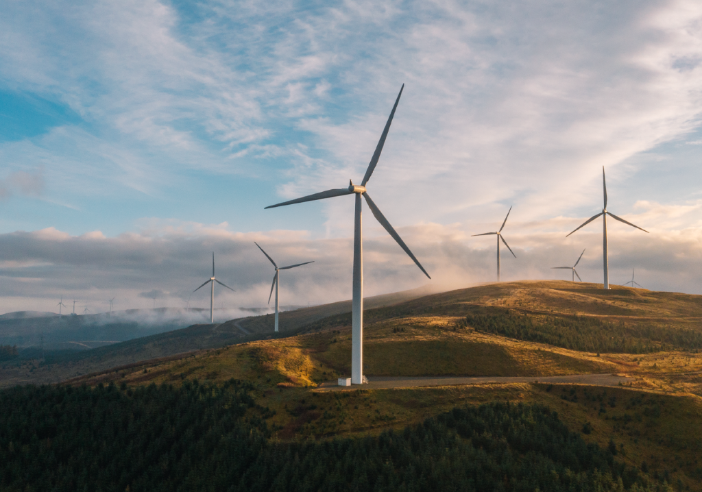 A landscape image of wind turbines with a hilly backdrop