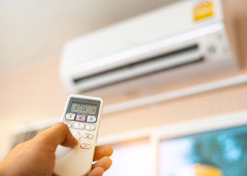 A stock image of an out-of-focus air conditioner, with the remote in the foreground.